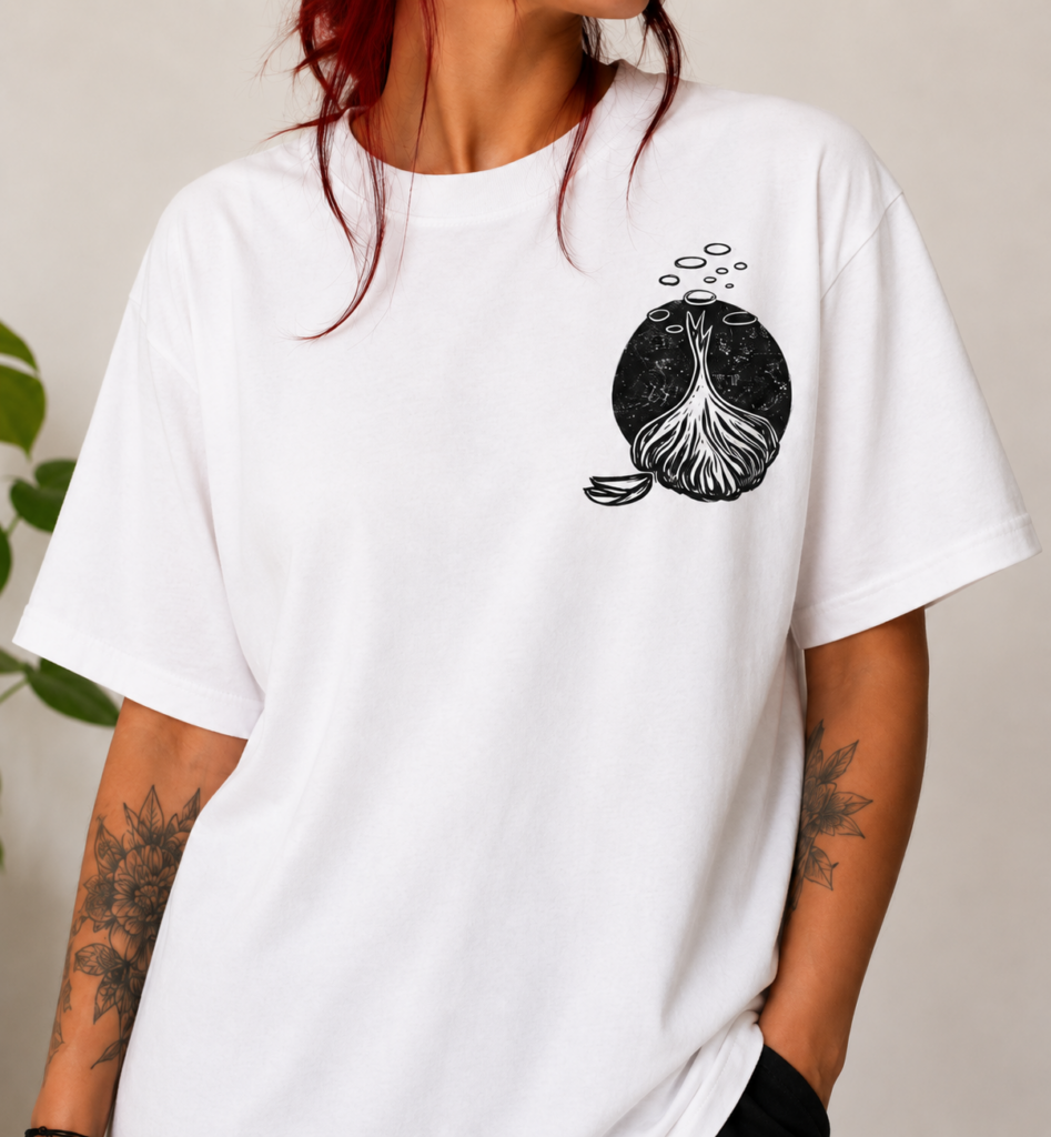 Camiseta artesanal blanca estampada a mano con técnica de linograbado, diseño inspirado en la tierra y las raíces