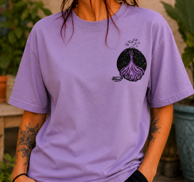 Camiseta lila artesanal estampada a mano con técnica de linograbado, diseño inspirado en la tierra y las raíces
